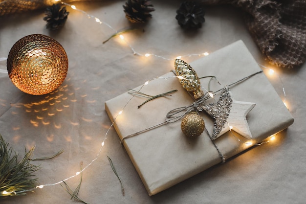 Composição de natal em fundo de papel artesanal com caixa de presente, galhos de abeto, brinquedos copiam espaço para suas felicitações