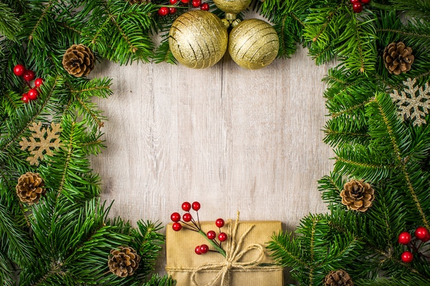 Composição de Natal em madeira fundo para suas saudações de férias de inverno. Presentes de Natal, pinhas, visco, flocos de neve em um fundo escuro texturizado.