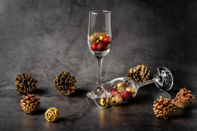 Composição de Natal em um fundo escuro com taças de champanhe vazias e brinquedos de Natal