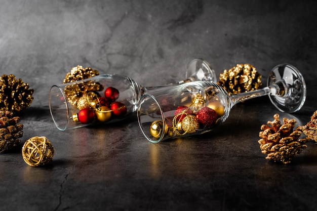 Composição de Natal em um fundo escuro com taças de champanhe vazias e brinquedos de Natal