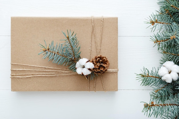 Composição de Natal feita de presente decorado com galhos de árvore de abeto protuberâncias de algodão em branco woo ...