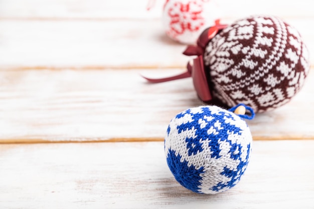 Composição de Natal ou Ano Novo. Enfeites, bolas de malha, sobre um fundo branco de madeira. Vista lateral, cópia espaço, foco seletivo.