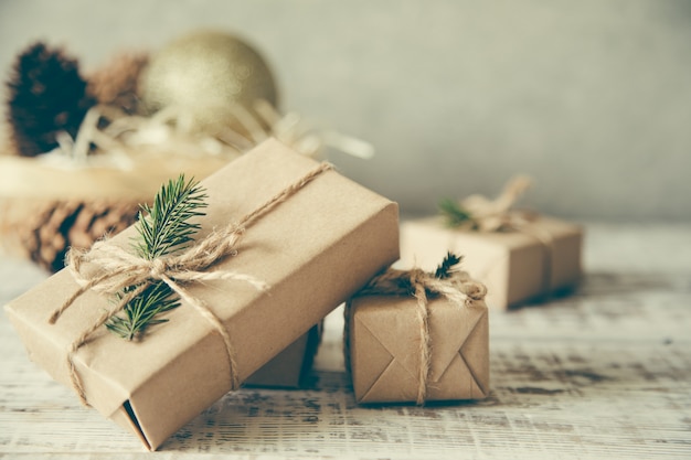 Composição de Natal. Presente de Natal, pinhas, ramos de abeto em fundo branco de madeira.