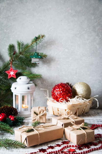 Composição de Natal. Presente de Natal, pinhas, ramos de abeto em fundo branco de madeira.