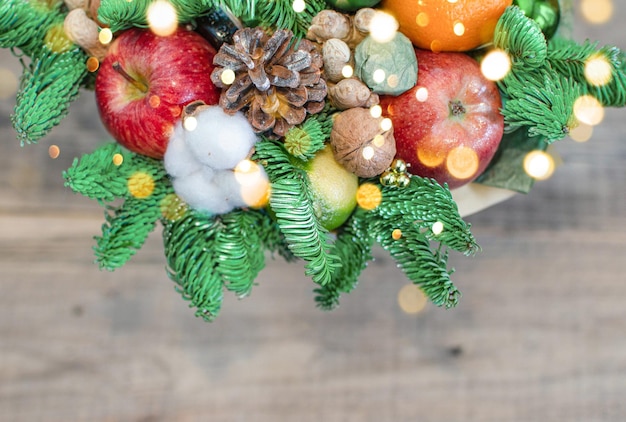 Foto composição de natal, um buquê de galhos de uma árvore de natal, maçãs, doces, laranja