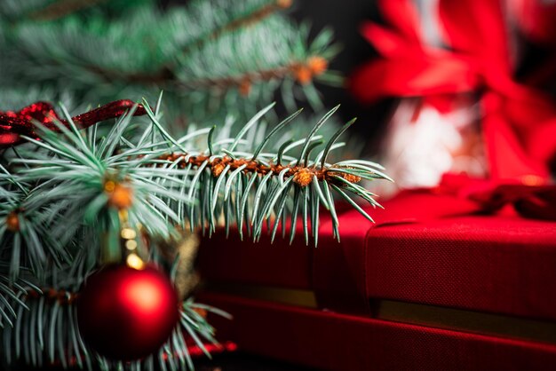 Composição de Natal. Uma árvore de Natal decorada com brinquedos e uma guirlanda e presentes ao lado dela. Foto de alta qualidade