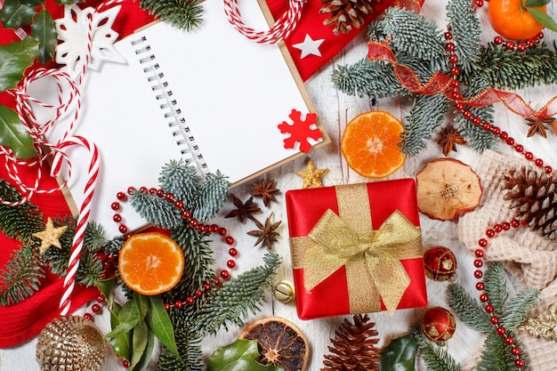 Composição de Natal vermelha e dourada com caderno e caixa de presente