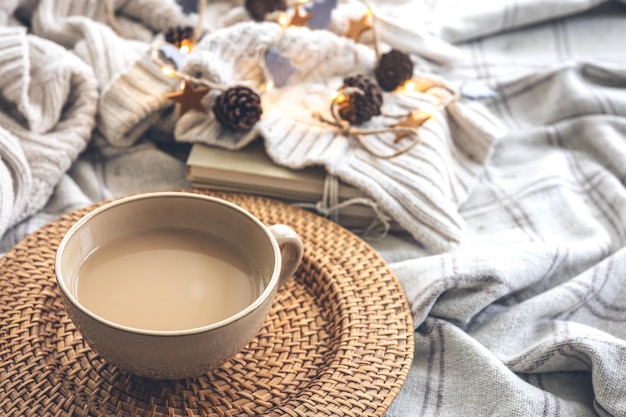 Composição de outono aconchegante com uma grande xícara de café na cama