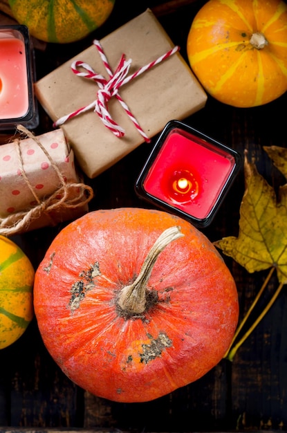 Composição de outono com abóboras de velas e folhas de outono xícara de chá na mesa de madeira