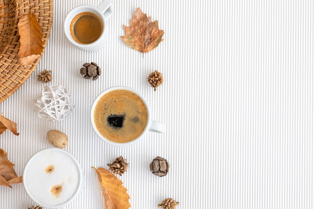 Composição de outono com xícaras de café e folhas em um fundo branco