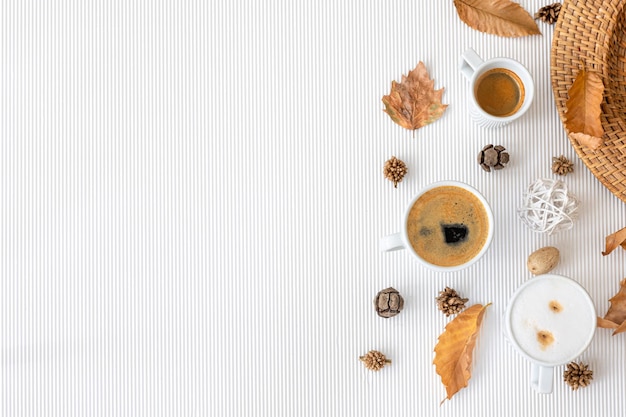 Composição de outono com xícaras de café e folhas em um fundo branco