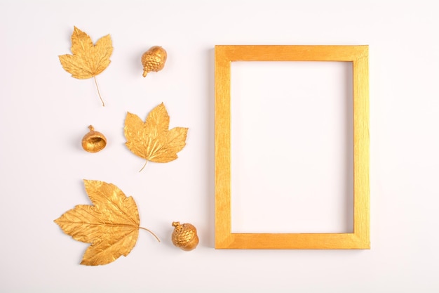 Composição de outono Folhas douradas bolotas e molduras para fotos em um fundo claro Vista superior Copiar espaço