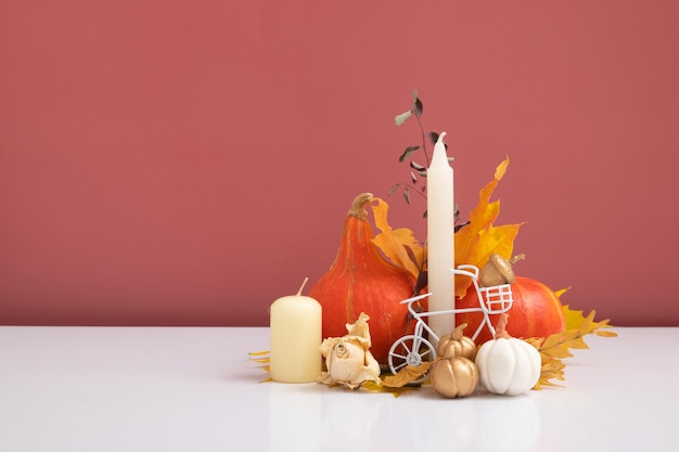 Composição de outono folhas secas de abóboras e velas em fundo rosa branco queda de outono e conceito de dia de ação de graças ainda vida