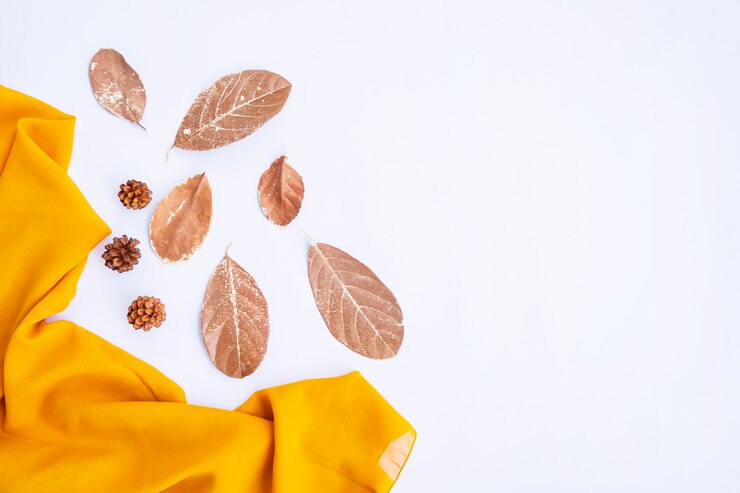 Foto composição de outono. lenço amarelo, folhas secas em fundo branco. outono, conceito de outono. camada plana, vista superior, espaço de cópia