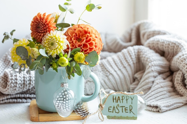 Composição de páscoa com um buquê de flores e um elemento de malha