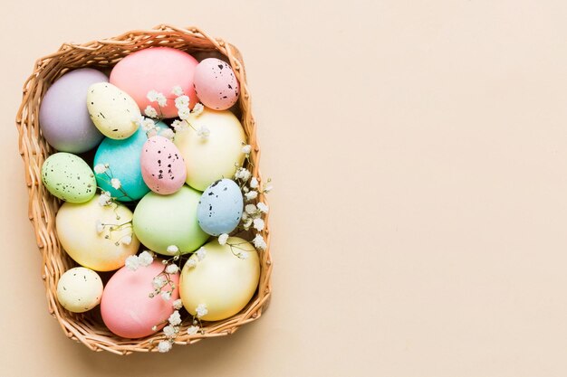 Composição de Páscoa Feliz Ovos de Páscua em cesta em mesa colorida com gipsófila Ovos coloridos naturais de fundo vista superior com espaço de cópia