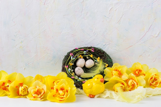 Composição de Páscoa: frango, ninho com ovos, penas, narcisos