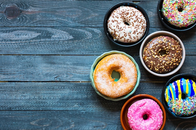 Composição de pequeno-almoço colorido donuts com estilos de cores diferentes