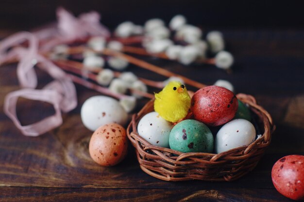 Composição de primavera com ovos de páscoa em uma cesta e salgueiro