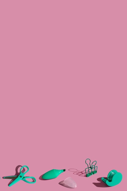 Composição de quadro plano leigo com material de papelaria verde escolar em fundo rosa pastel Cor vívida tiro mínimo com espaço de cópia De volta ao conceito de escola Vista superior com sombras nítidas