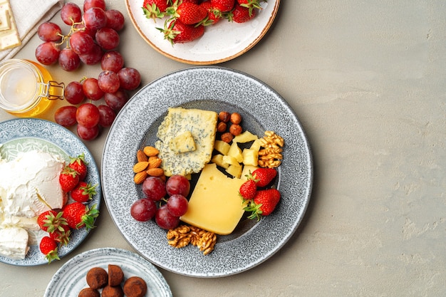 Composição de queijo e frutas no fundo da mesa cinza