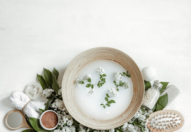 Composição de spa com água para tratamentos de beleza e flores frescas.