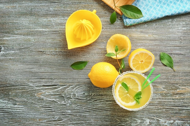 Composição de suco de limão e frutas frescas em fundo de madeira