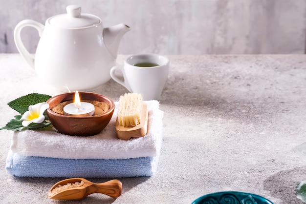Composição de terapia de spa resort. Queima de velas, toalha, jogo de chá e flores em uma pedra, copyspace