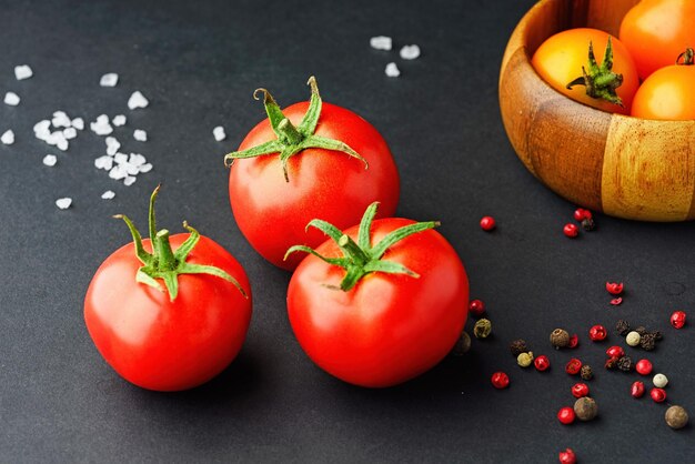 Foto composição de tomates vermelhos e amarelos sobre um fundo preto