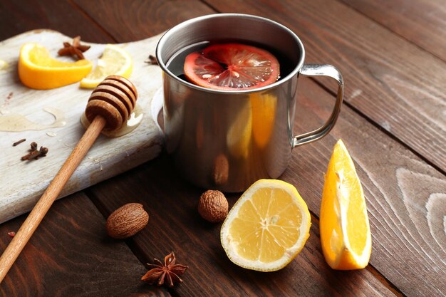 Composição de vinho quente, canela e frutas cítricas em fundo de madeira