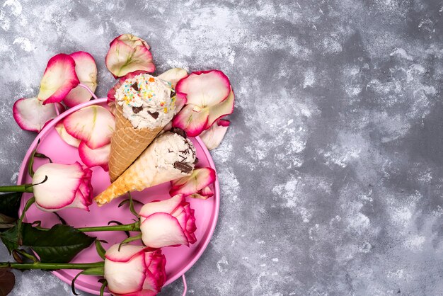 Composição de waffles de sorvete com buquês de rosas em um fundo de pedra