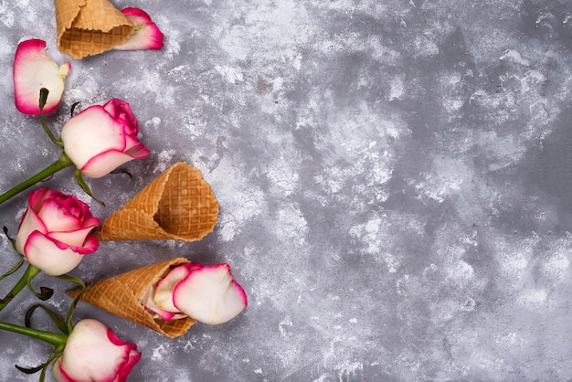 Composição de waffles de sorvete com buquês de rosas em um fundo de pedra