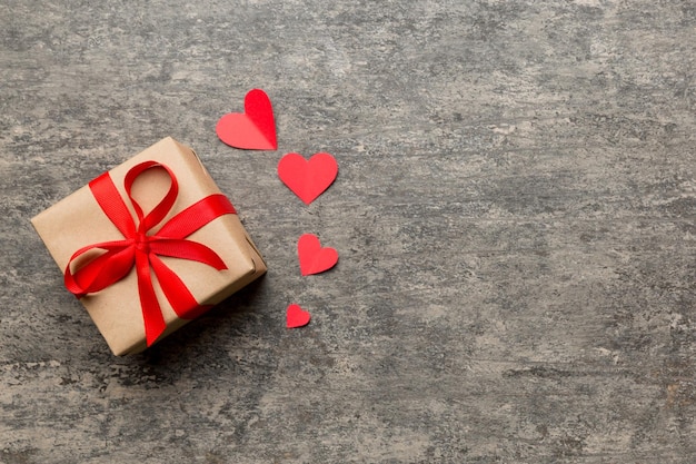 Composição do dia dos namorados caixa de presente vermelha com arco e coração presente de Natal Vista de cima Espaço para texto Cartão de boas-vindas