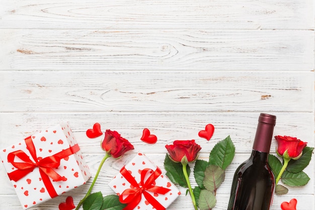 Composição do dia dos namorados com flor rosa de vinho tinto e caixa de presente na mesa Vista superior plana conceito de férias