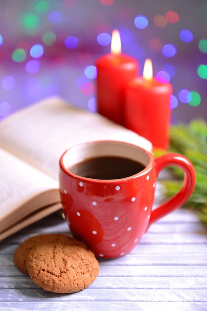 Composição do livro com uma xícara de café e decorações de Natal na mesa com fundo brilhante