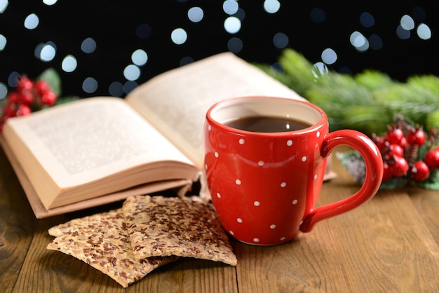 Composição do livro com uma xícara de café e enfeites de Natal na mesa