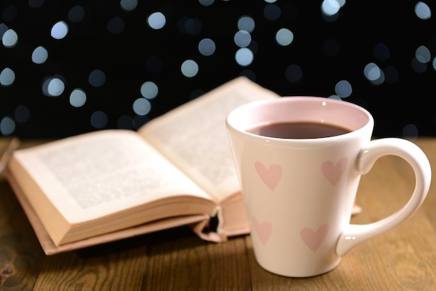 Composição do livro com uma xícara de café na mesa em fundo escuro