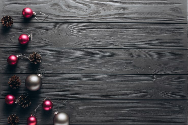 Composição do Natal: fundo cinza de madeira com cones de pinheiro, pequenas bolas de cor-de-rosa e grandes