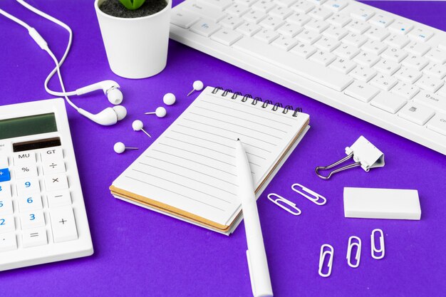 Composição dos itens de estilo de vida do escritório em roxo, material de escritório para teclado de computador na mesa no escritório