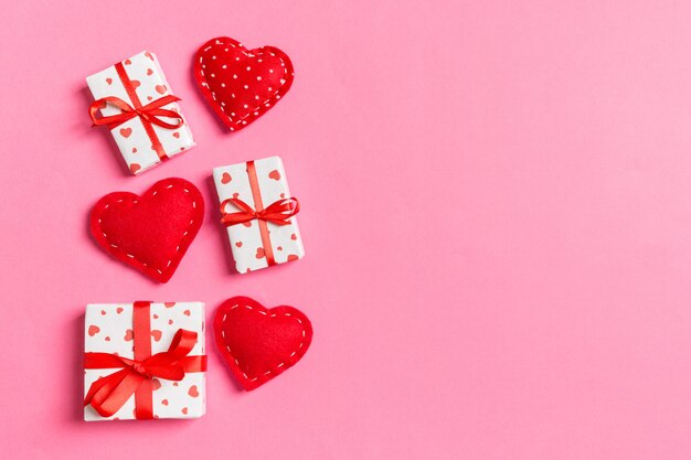 Composição dos namorados de caixas de presente e corações vermelhos têxtil