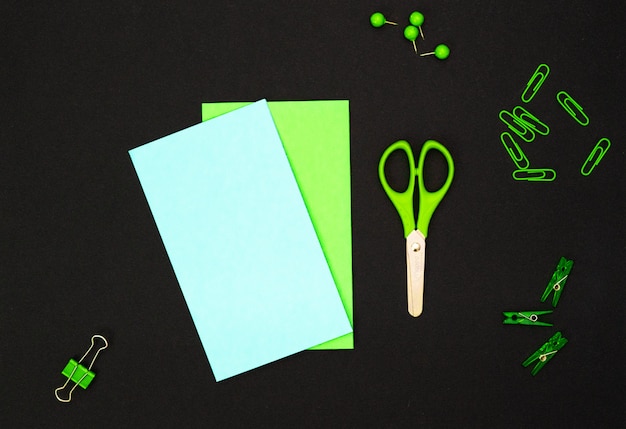 Composição educacional, artigos de papelaria. Artigos de papelaria verde e caderno verde no preto