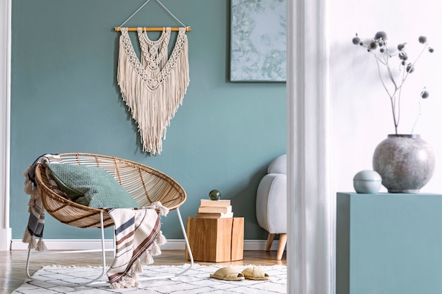 Composição elegante do interior criativo e aconchegante da sala de estar com mesa de centro, poltrona de vime, plantas, carpete e lindos acessórios boho. Paredes de eucalipto e chão em parquet.