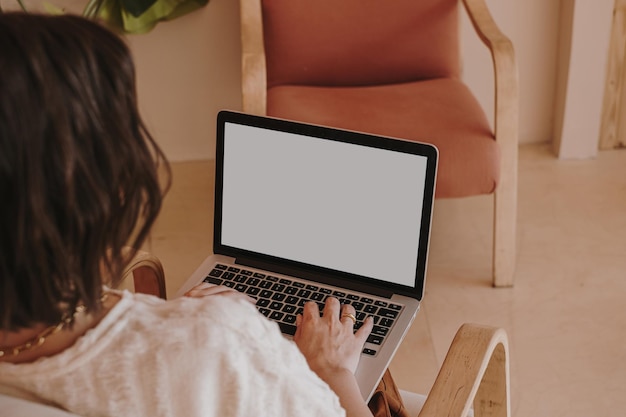 Composição estética com jovem mulher bonita trabalhando em laptop com tela de espaço de cópia Design de interiores moderno
