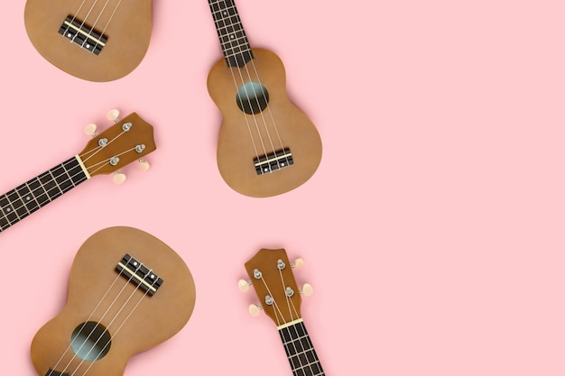 Composição feita de ukulele em um fundo rosa pastel