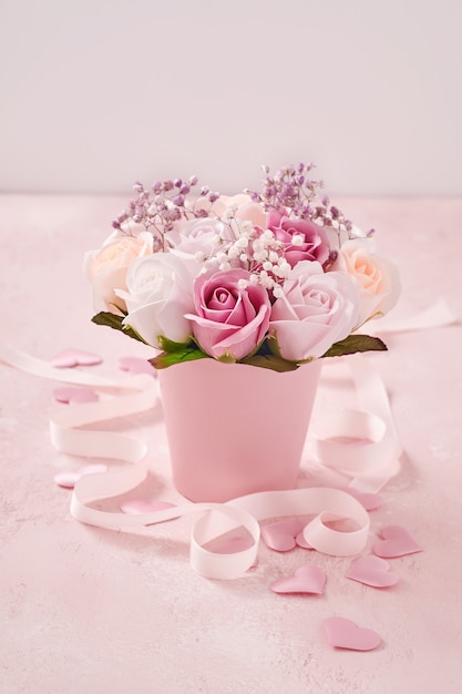 Composição festiva com lindas flores delicadas rosas em caixa redonda rosa sobre fundo rosa claro. Cartão de feliz dia das mães. Postura plana, copie o espaço.