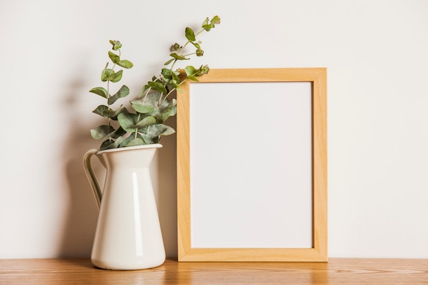 Foto composição floral com quadro ao lado da planta