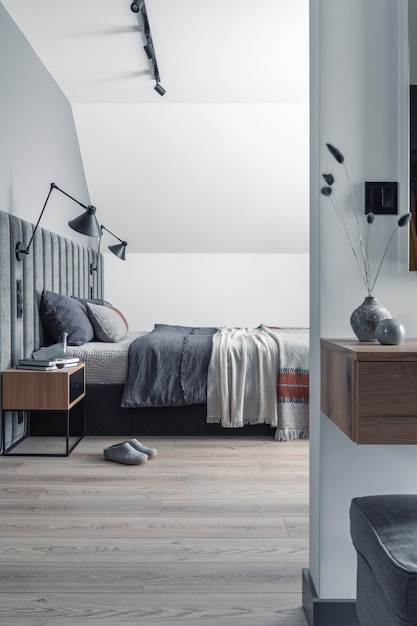 Composição minimalista do interior do quarto com prateleira de lâmpada de design de prateleira de cama de veludo e acessórios elegantes Lindos lençóis de cama cobertor e travesseiro Modelo Design decoração para casa