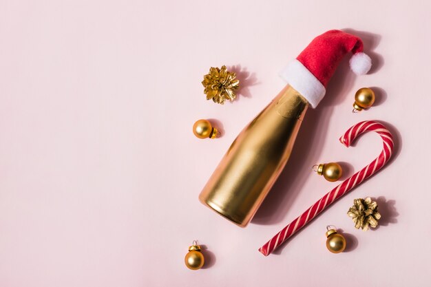 Composição moderna de Natal feita de champanhe dourado em bengala e brinquedos de chapéu de Papai Noel