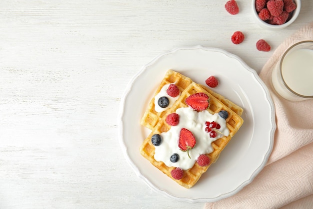 Composição plana com deliciosos waffles e frutas frescas na mesa de madeira branca Espaço para texto