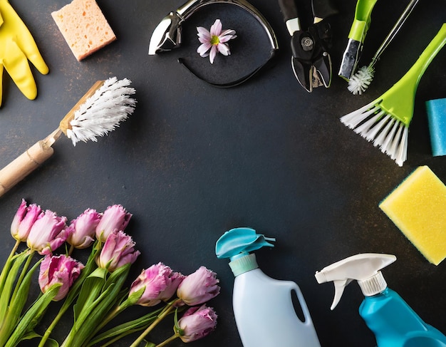 Foto composição plana com suprimentos de limpeza ferramentas e flores de primavera em fundo colorido com cop...